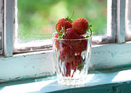 glass of strawberries on window-sill